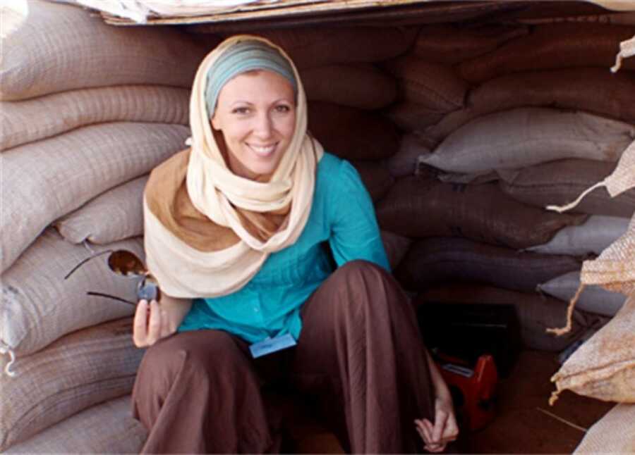 woman sitting in a hut with a headscarf