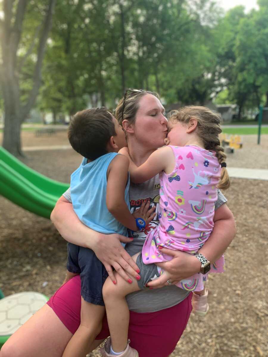 mom kissing her daughter on the head