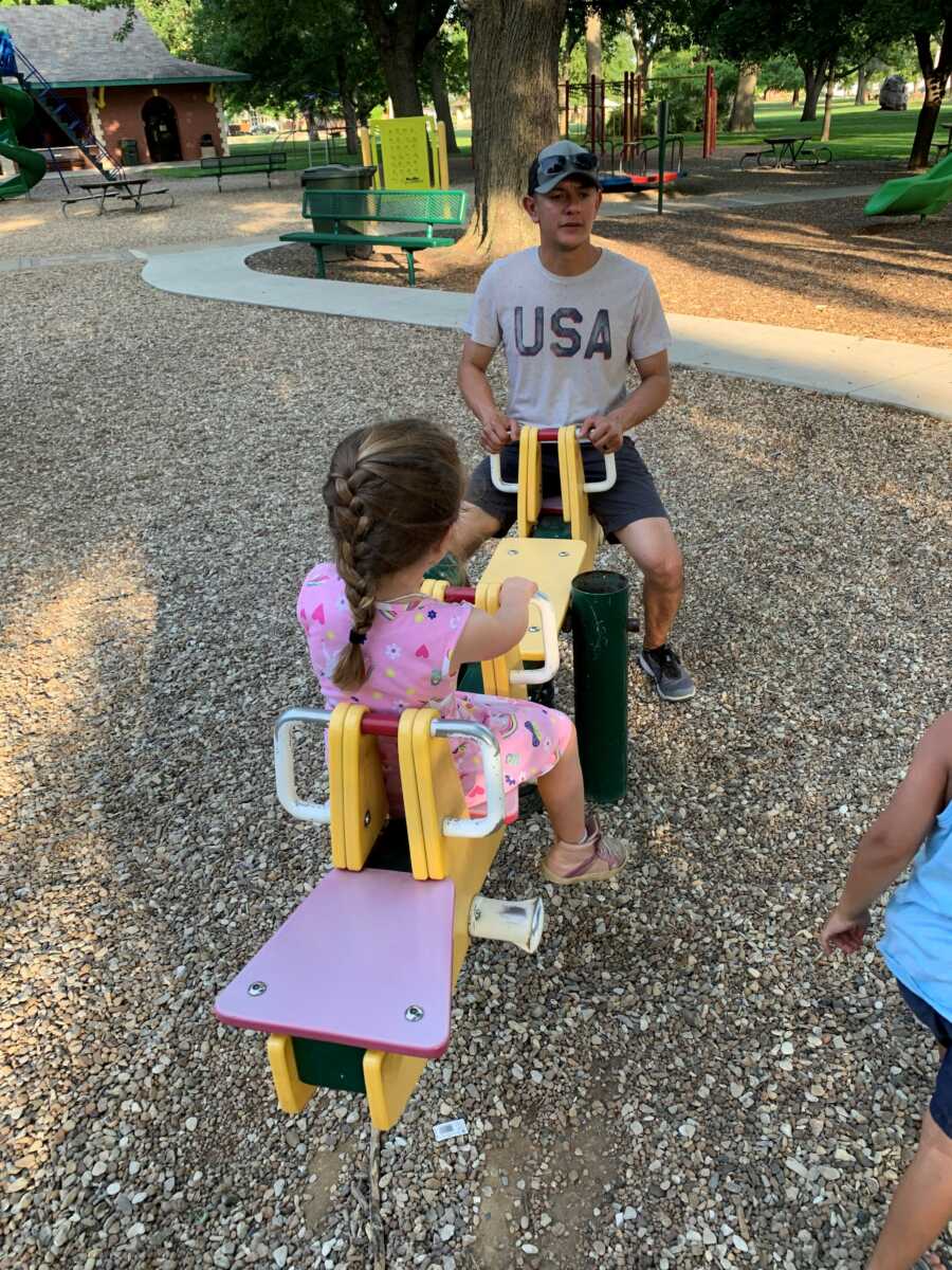 two kids playing on a seesaw togeher