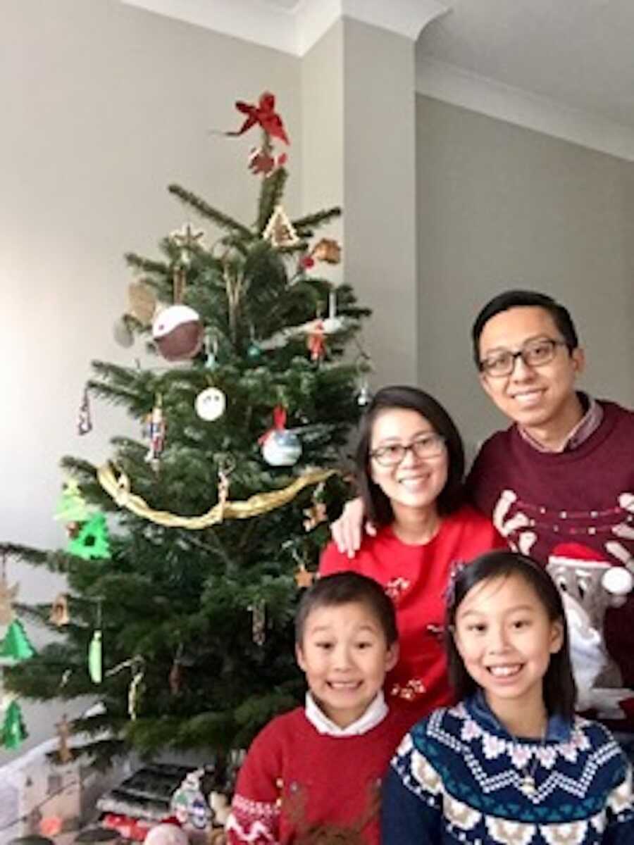 family posing by the Christmas tree