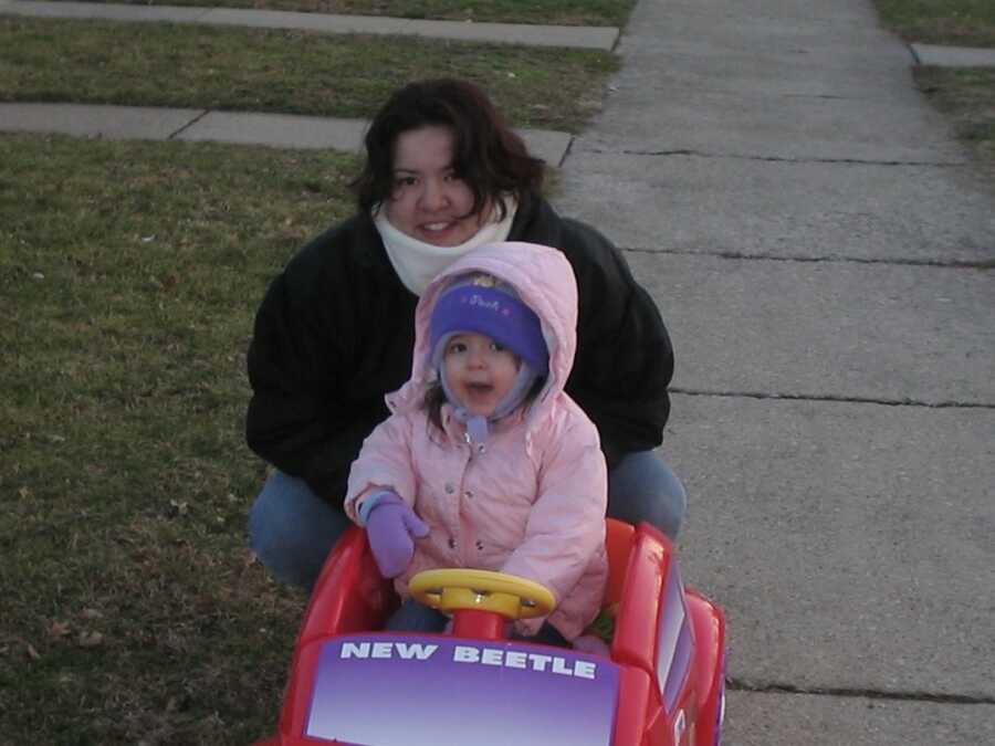 young child in a toy car