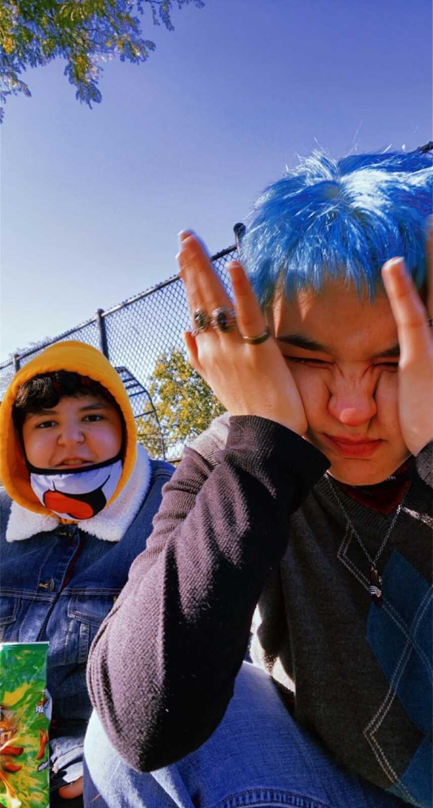 two teens outside by a fence