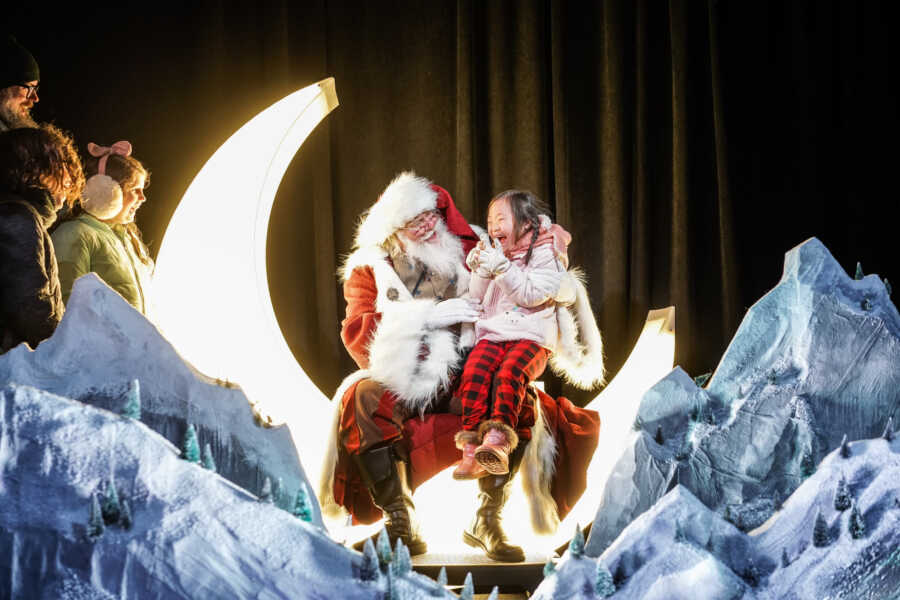 santa sitting with a little girl on the moon