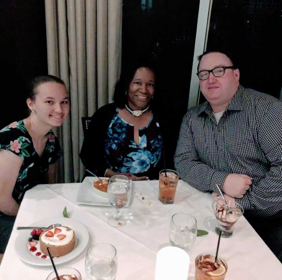 Family of three take a photo together while out at dinner