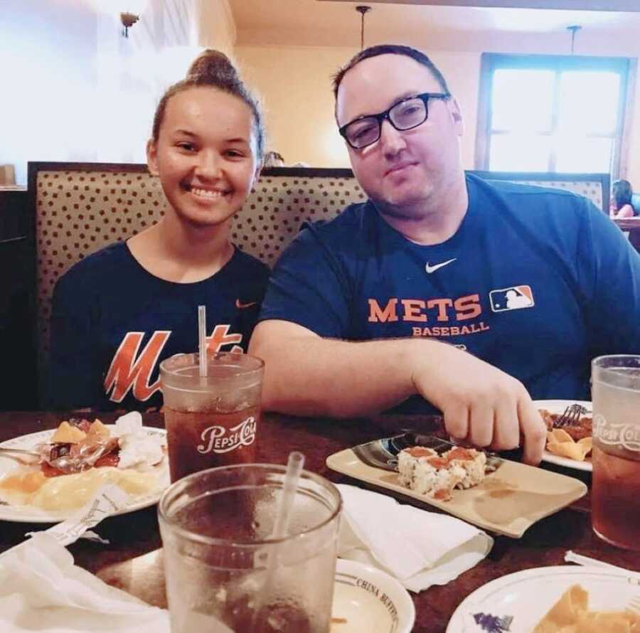 Dad and daughter smiler big for a photo while enjoying lunch together