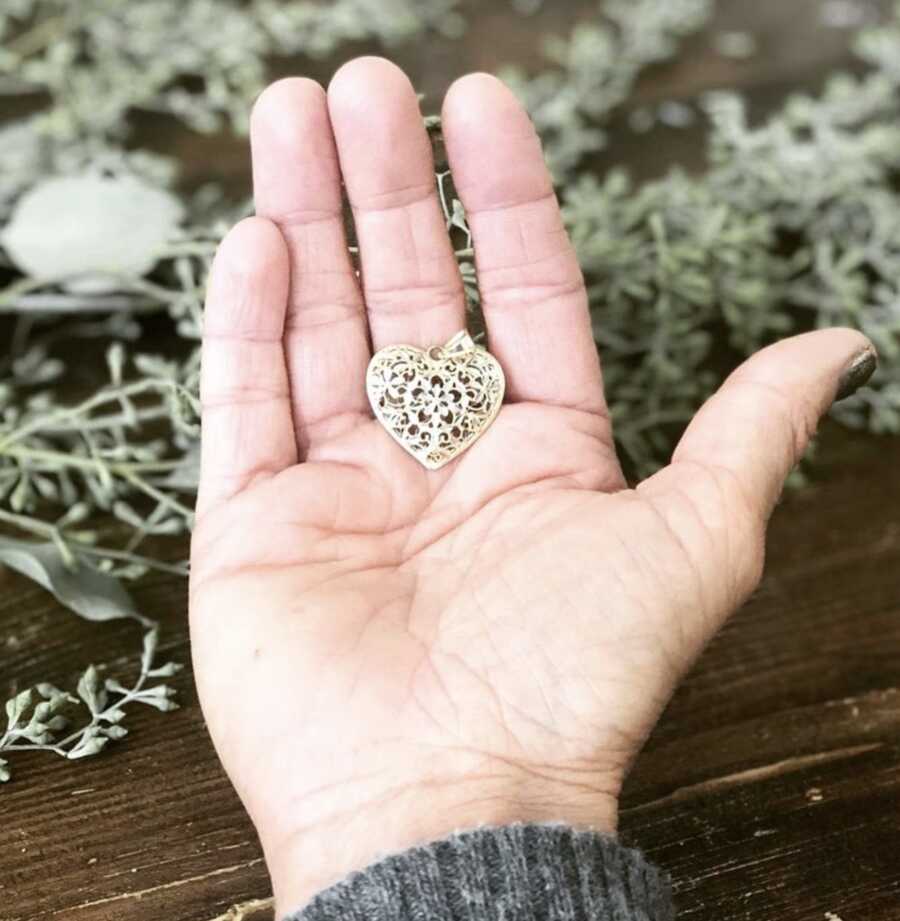 woman holding a heart shaped charm