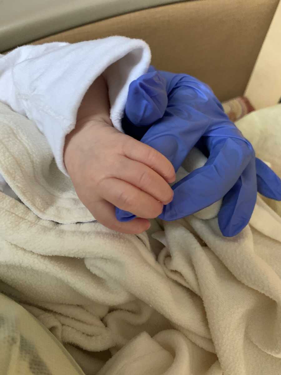 son's little hand wrapped around his mom's hand