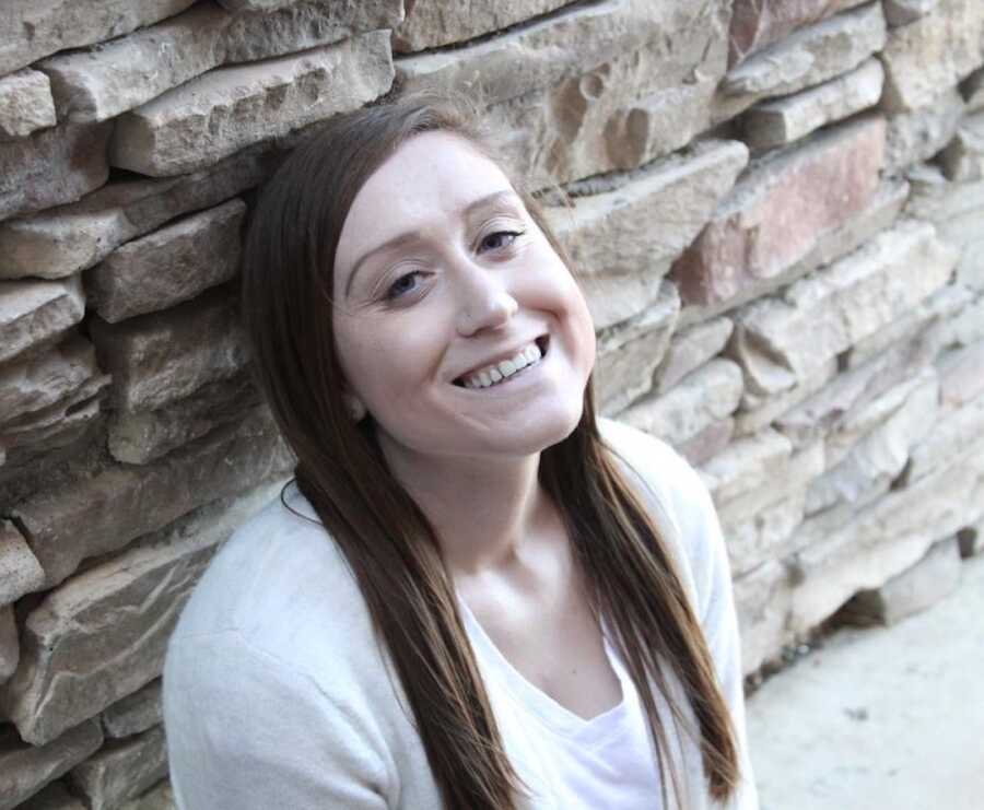 woman sitting in front of a brick wall