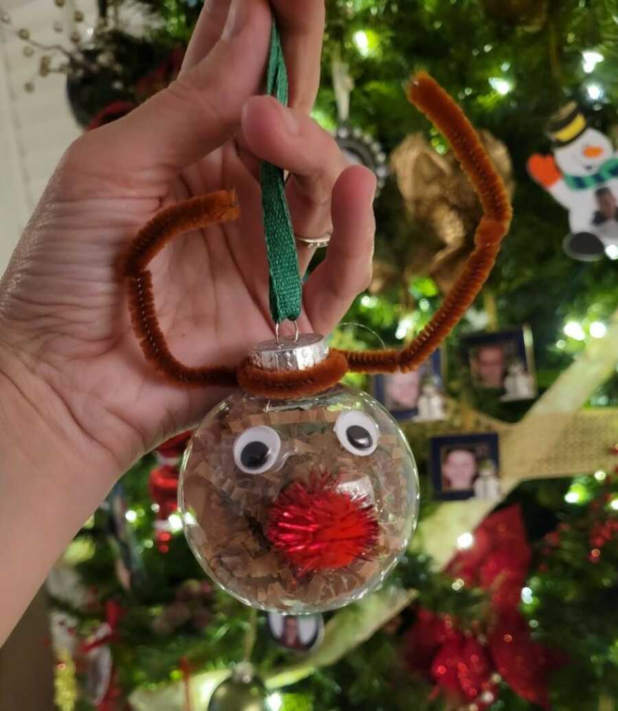 mom showing the ornament her child made for her