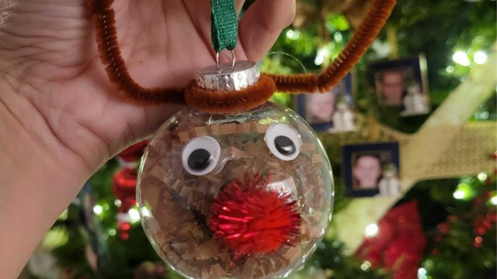 mom showing the ornament her child made for her