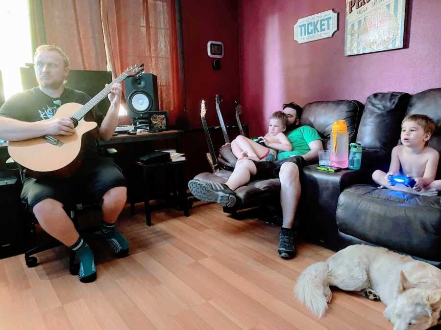 Blended family sit around and play music together