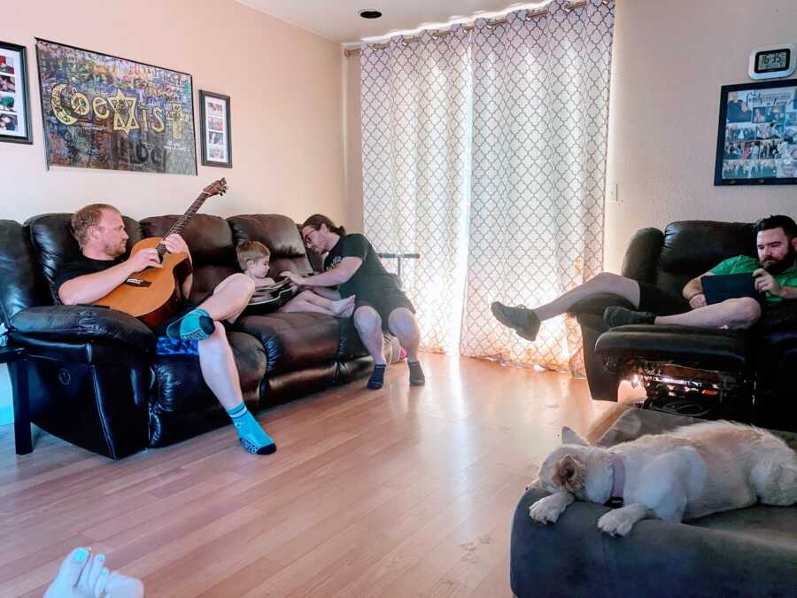 Man tries to teach his young step son how to play the guitar