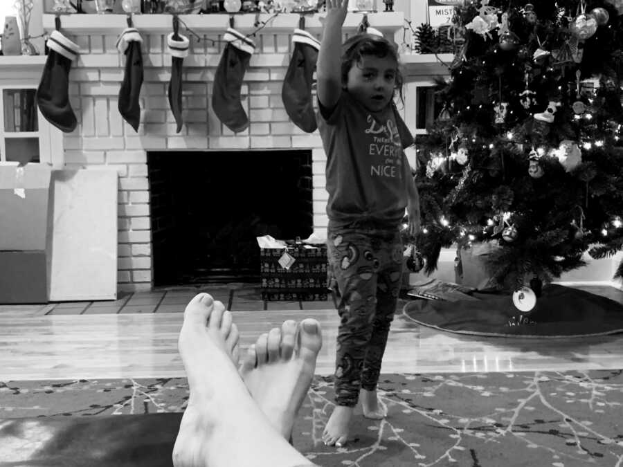 one kid dancing for their mom in front of the fire place