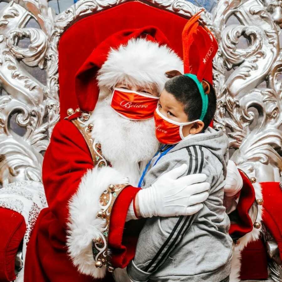 little boy telling santa what he wants for christmas in the north pole