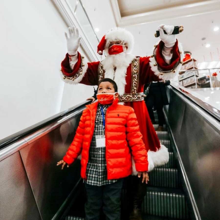 little boy with santa going down the escalator 