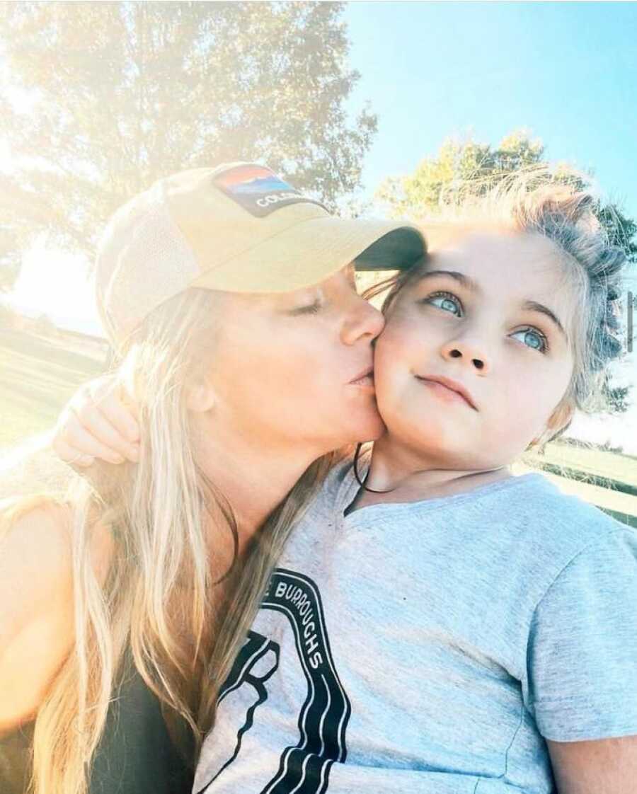 Mom kisses daughter with autism on the cheek