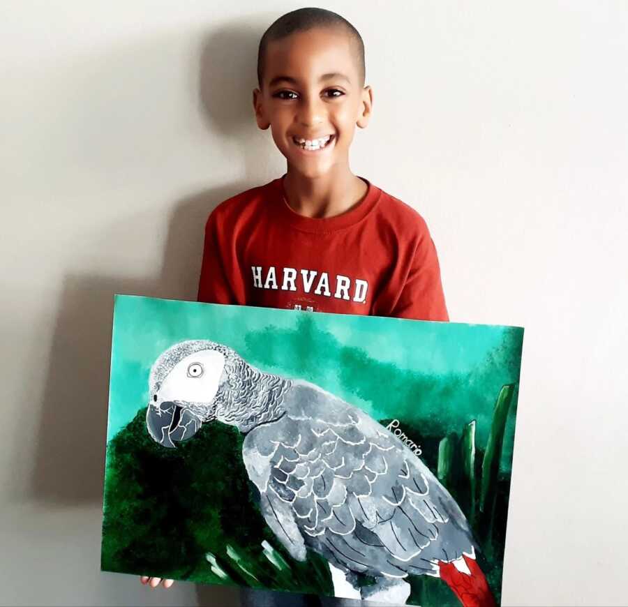 little boy with a painting of his favorite endangered bird that he painted