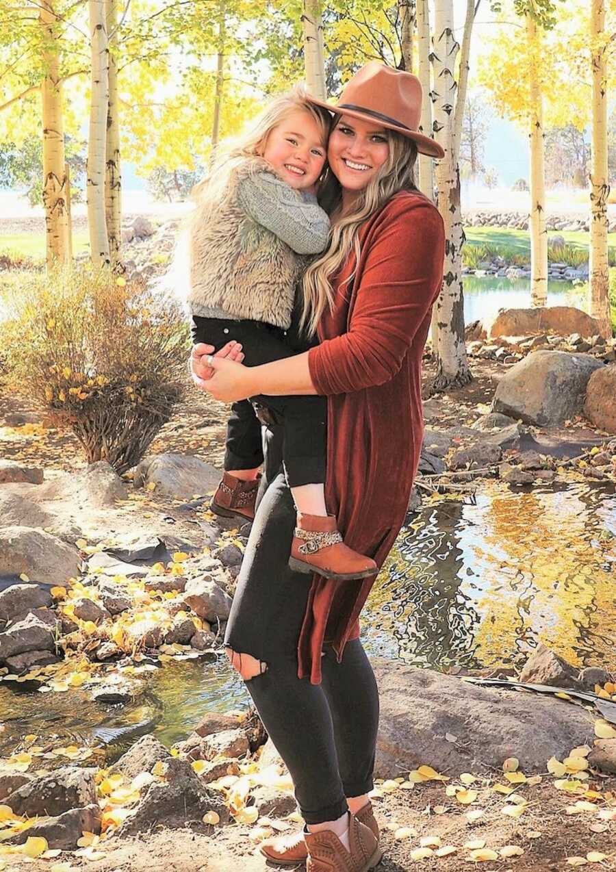 mom holding her daughter outside