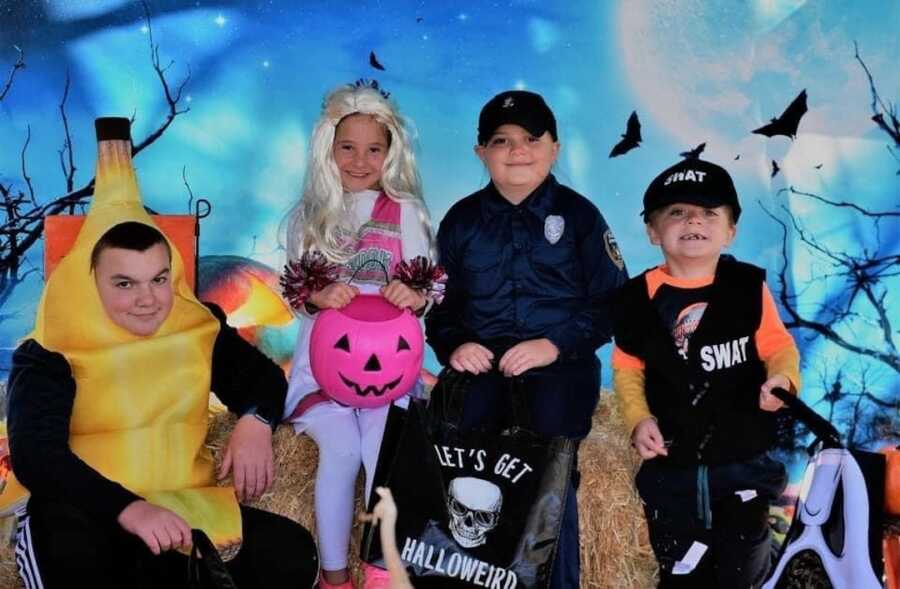 four kids in halloween costumes