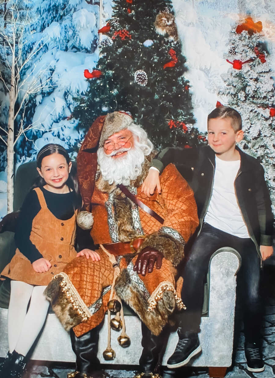 little girl with her brother posing with a santa