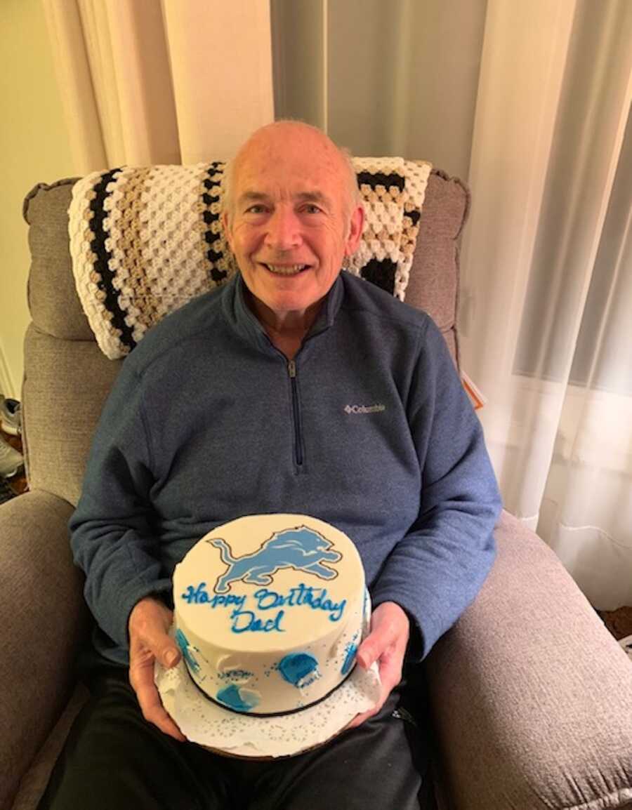 older man holding a birthday cake