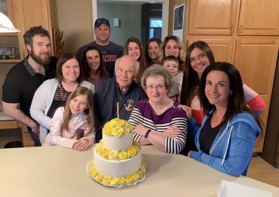 big family gathering around a cake