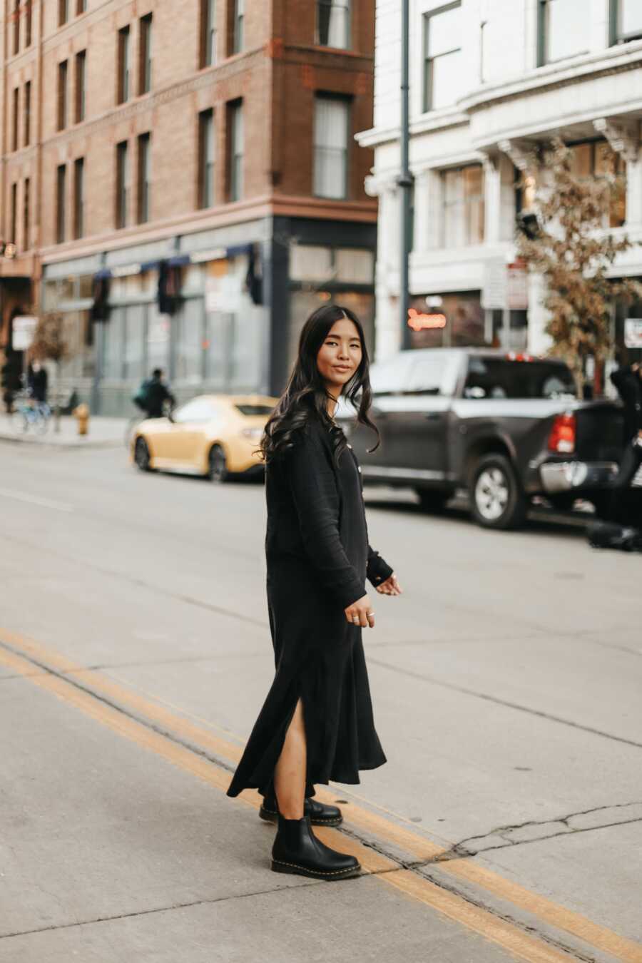 woman crossing the street posing for a photo 