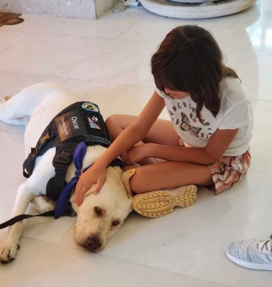 little girl with the therapy dog, petting him on the floor