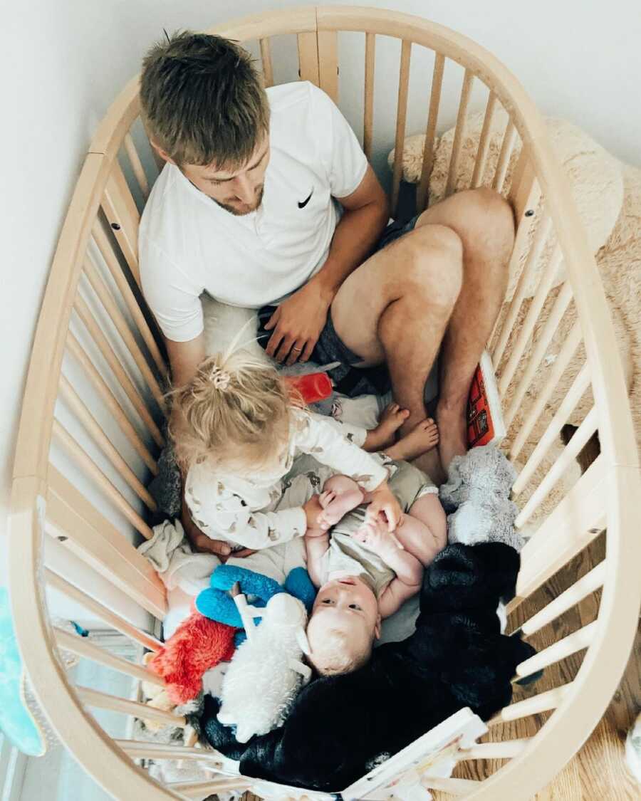 dad in the crib with his two kids