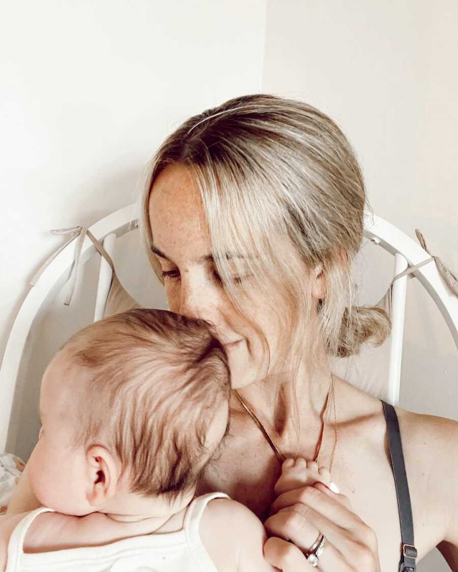 Mom sits in a rocking chair holding her baby.