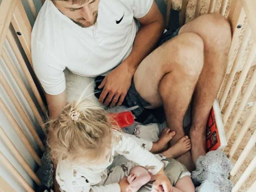 dad in the crib with his two kids