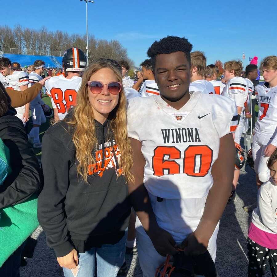 mom with her son after he is done playing his football game