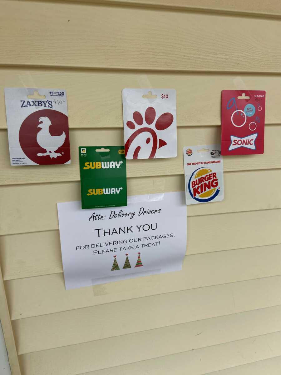 woman tapes up gift cards on her house as a thank you to delivery drivers