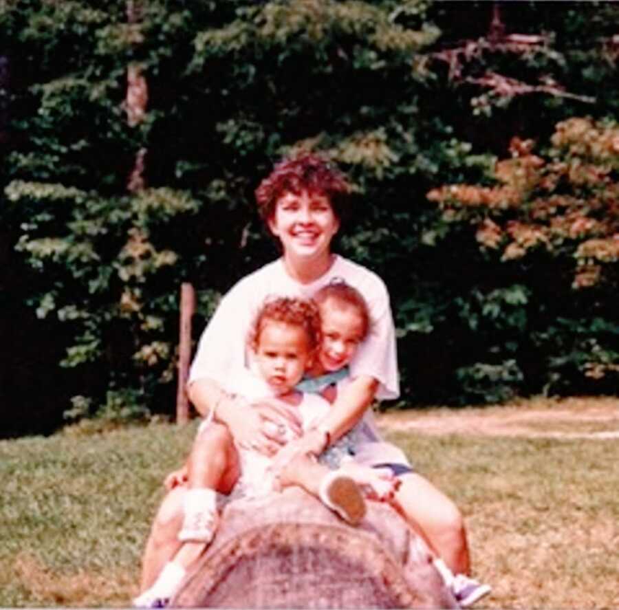 A mom sitting with her two adopted daughters