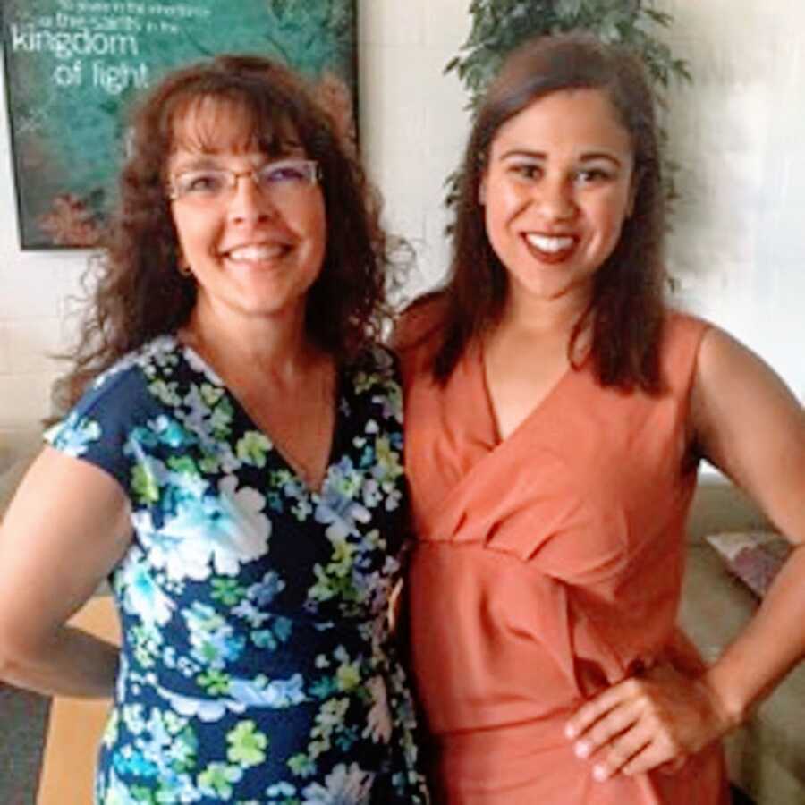 An adoptee stands with a woman in glasses