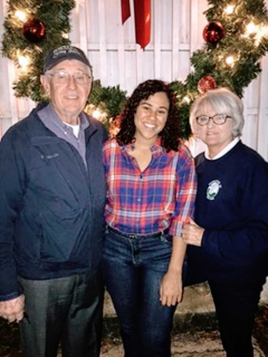 An adoptee with her parents by a wreath