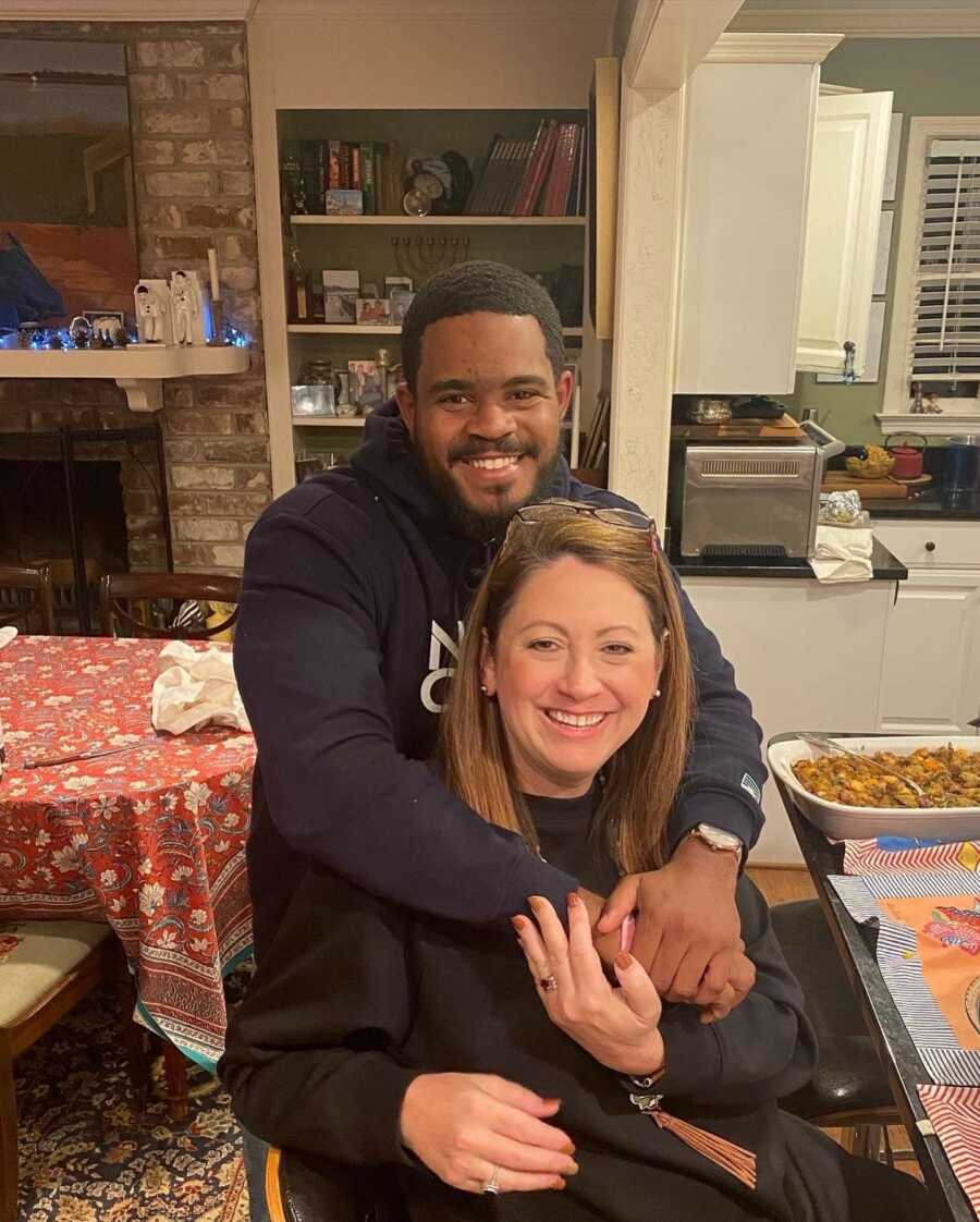 man with his adopted sister while they hug and smile