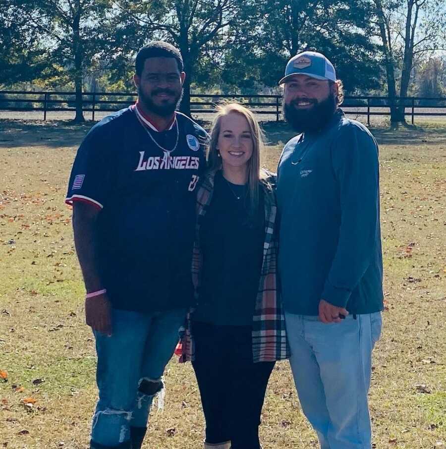 man with his sister in law and brother in law smiling for the camera