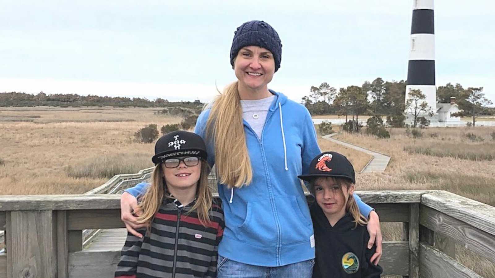 A mom and her sons by a lighthouse during the holidays