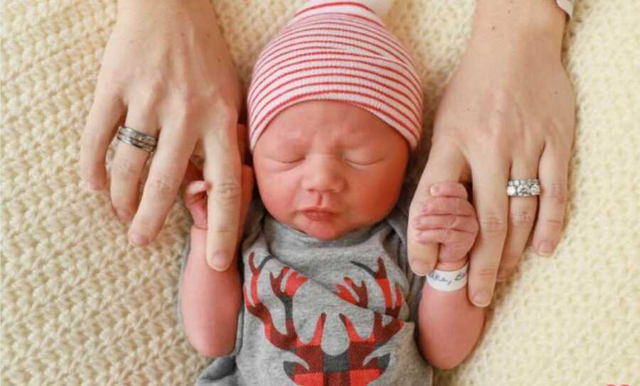 new born baby holding his mom's fingers are being born early