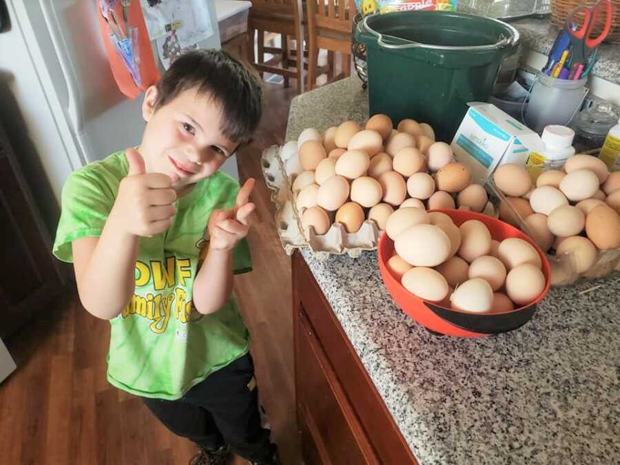 Jayden poses next to the fresh farm eggs he's selling for Toys for Tots.