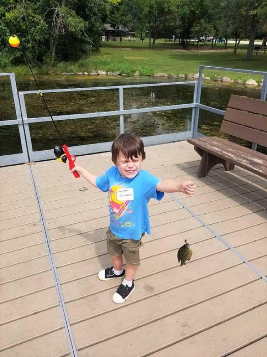 Young Jayden holds up a fish he just caught. 