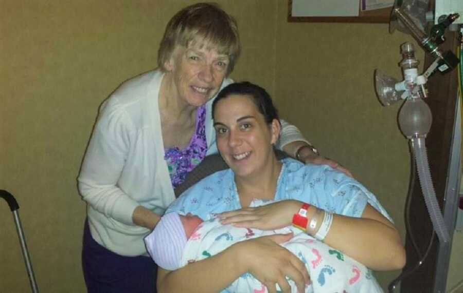 Mom holds newborn baby boy in the hospital delivery room. 