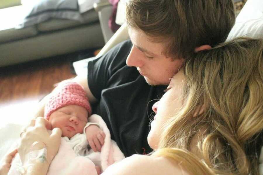 mom and dad with daughter after birth