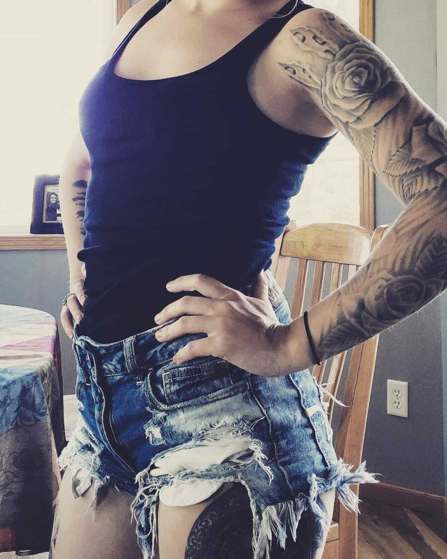 Woman takes picture showing off her tattoo sleeve. 