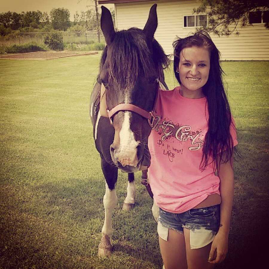 Teen girl takes a picture with her horse. 
