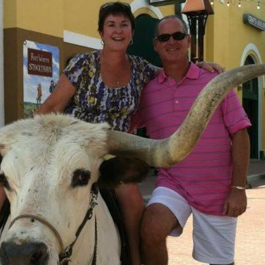 wife and husband on a vacation riding a bull