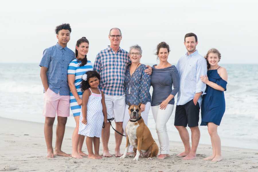 family photo of wife and husband on a beach posing for a family photo