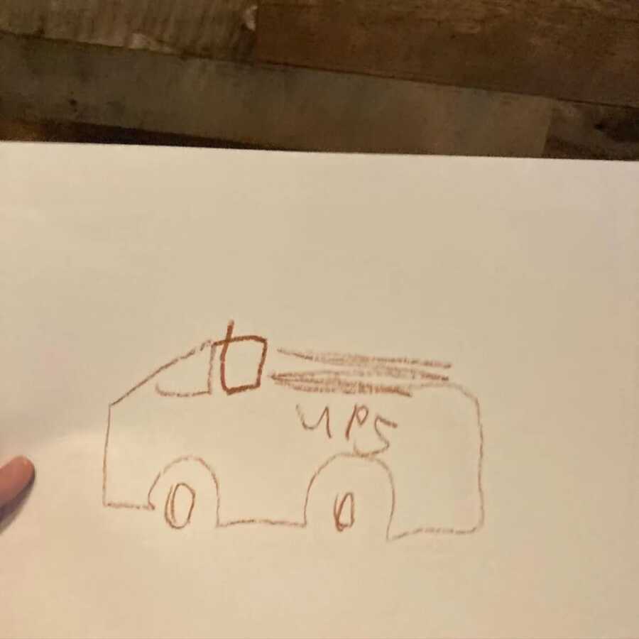 little boy using a brow crayon to draw his ups truck
