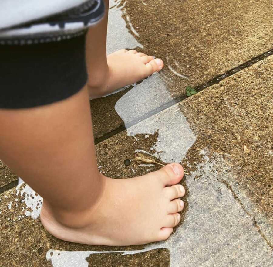 little boy with his feet in the rain water